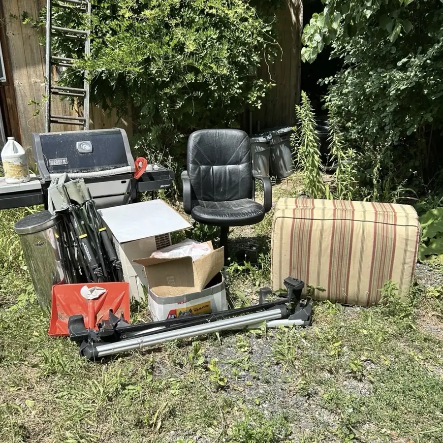 Before: Grill, office chair, cushion and other items piled outside